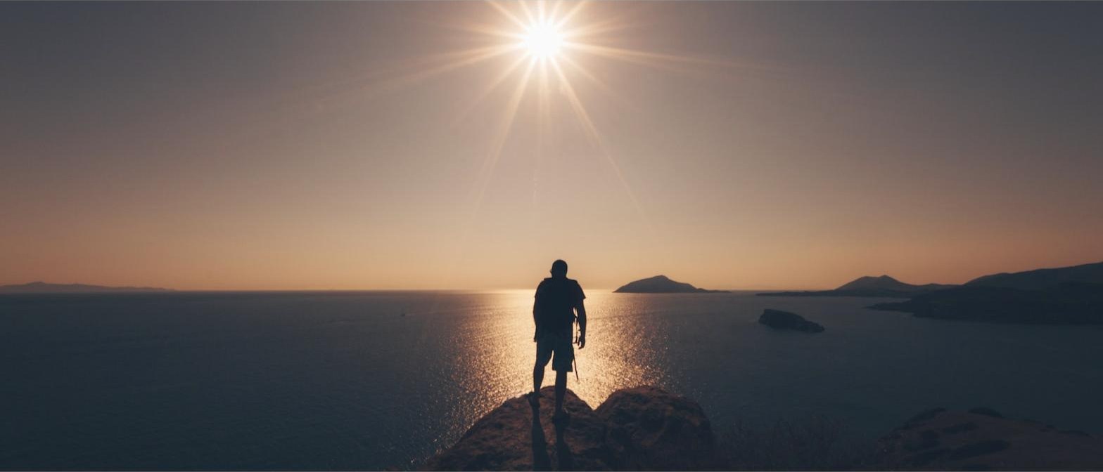 Silhueta contemplando o horizonte ao entardecer, símbolo de visão de longo prazo