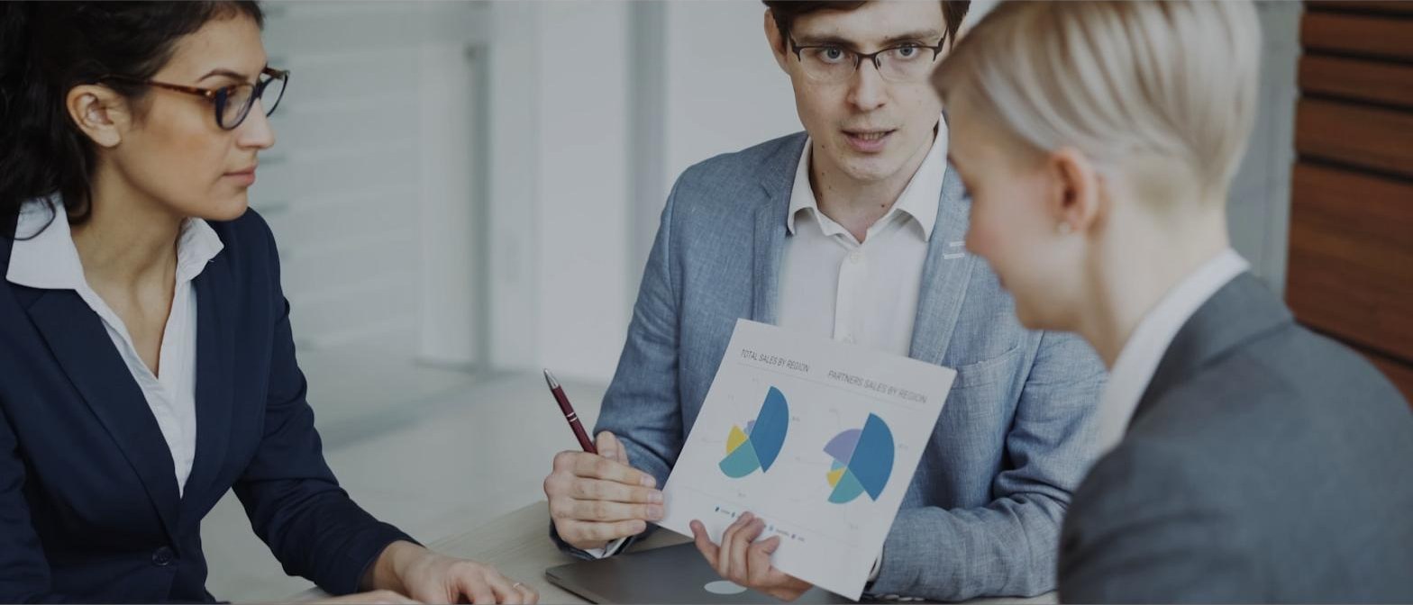Executivos analisando gráficos de resultados consolidados em reunião